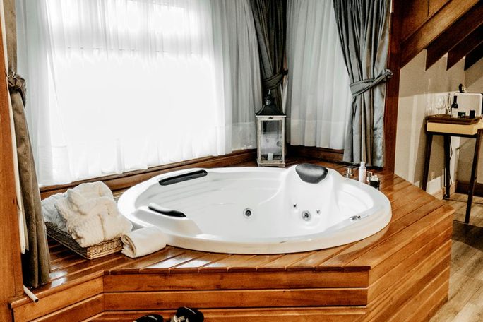 A spa suite with a sunken tub and timber walls